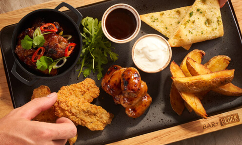 A hand touching the Bar and Block House Sharing Platter
