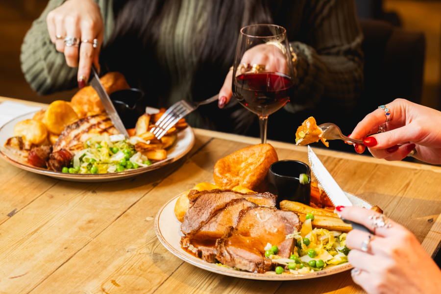 Plate of Bar and Block Sunday roast featuring roast beef, Yorkshire pudding, crispy potatoes, and seasonal vegetables.