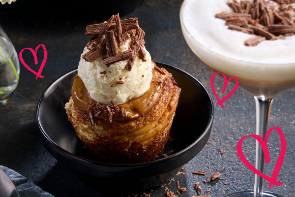 Cinnamon bun dessert topped with ice cream served alongside a S’mores Martini cocktail.